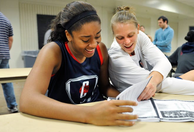 Connecticut's Morgan Tuck and Heather Buck laugh while looking at the media guide during their NCAA college basketball media day in Storrs, Conn., Tuesday, Oct. 16, 2012. ()