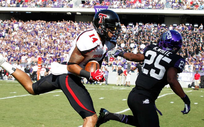Texas Tech wide receiver Darrin Moore (14) pulls in a touchdown pass against TCU cornerback Kevin White (25) during the first half Saturday of a Big 12 game in Fort Worth.