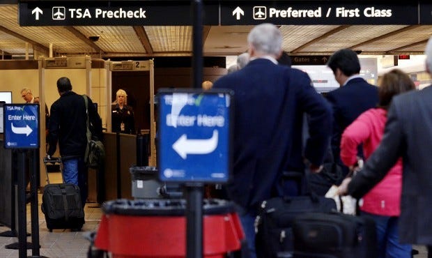 A traveler, left, moves smoothly through the TSA precheck as other travelers wait in line. TSA Pre expedited screening was implemented at the Pittsburgh International Airport for the first time on Tuesday, October 16, 2012.