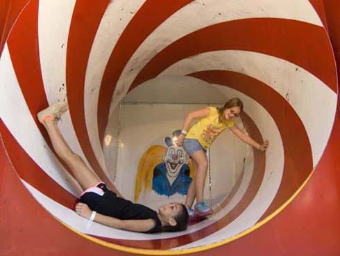 Hailey Viehman, left, and Taylor Sennet play in a rotating tube on the Clown City ride Saturday at the 36th Annual Boggy Bayou Mullet Festival in Niceville. The festival continues today, with gates opening at 10 a.m.