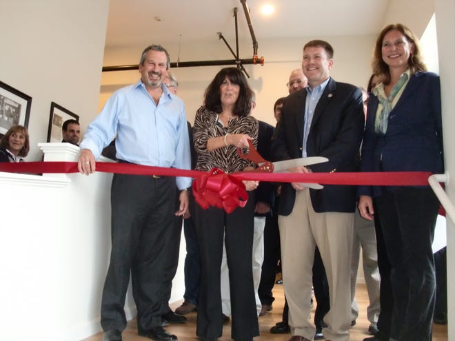 From left, Neighborhood Corporation President Dean Harrison, Robin Baron, Taunton Mayor Thomas Hoye Jr. and Taunton Business Improvement District Manager Terry Bernert cut a ceremonial ribbon to open the Baron Lofts and Trescott Gallery on Friday.