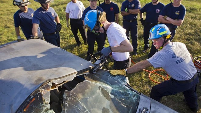 Austin Travis County EMS member Brenden Cluskey, left and EMS Captain Kem Larsen practice using a new tool to cut open a car as they prepare for the F1 races next month. The training occured on Saturday, Oct 20, 2012 at the fire department in Elroy, Texas.