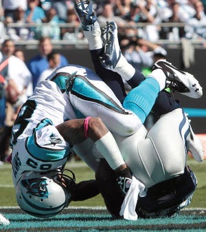 Panther wide reciever Steve Smith tackles Cowboy cornerback Morris Claibourne after he intercepted a pass in the endzone their game Sunday at Bank of America Stadium.