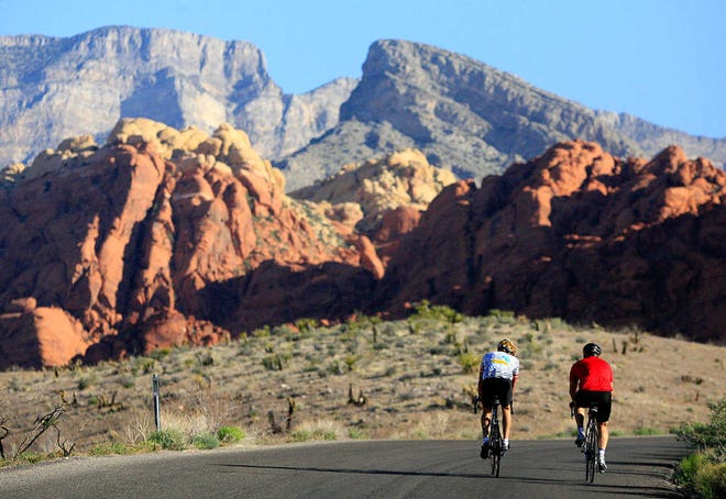 This May 6, 2006 file photo shows two cyclists riding along the 13-mile-long scenic drive at Red Rock Canyon National Conservation Area in Nevada. These towering red sandstone cliffs, some reaching 3,000 feet, is just 15 miles west of metropolitan Las Vegas.