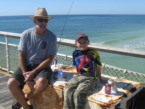7-year-old Rylin Bass takes a quick break from fishing to have a bite of his own with Grandpa Jim Davis. "I love fishing, I go every chance I can," said the second grade angler.