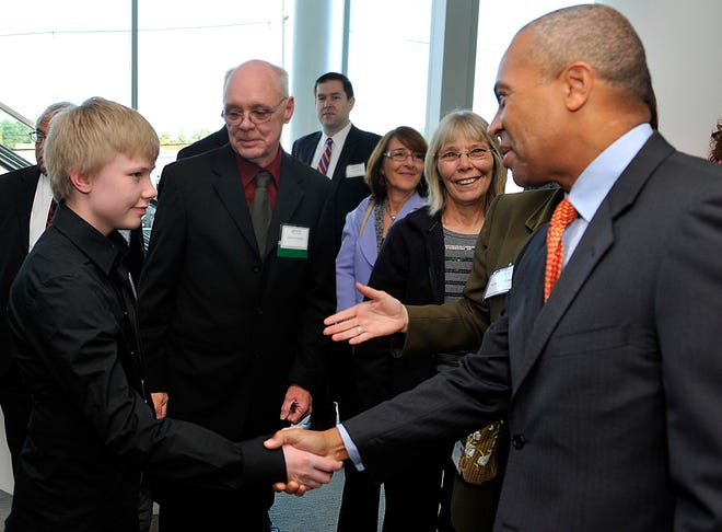 Gov. Deval Patrick shakes hands with Dexter Evan, 13, of Greenville, South Carolina, first recipient of the enzyme medication for Fabry Disease, at the celebration of the company's new biomanufacturing facility on New York Ave. in Framingham Monday.