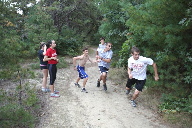 John Marchetti (right) takes a jump start on fellow cross country runners during practice.