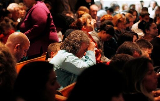 Mourners react during a packed overflow service Tuesday at Clayton Baptist Church in Clayton, N.J., as the small town tries to begin healing after missing 12-year-old Autumn Pasquale was found dead. Her body was found around 10 p.m. Monday, just blocks away from her house. Gloucester County Prosecutor Sean Dalton said two teenage brothers were charged Tuesday with murdering Pasquale, who had been missing since the weekend, prompting a frantic search by her small hometown.