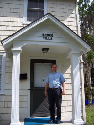 The Rev. Father Thomas Connery on steps of Bosco Villa.