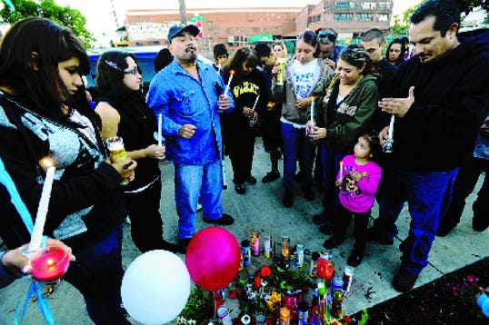 Dennis Martin Sr., center, leads a prayer Wednesday during the candlelight vigil for his son in Stockton.