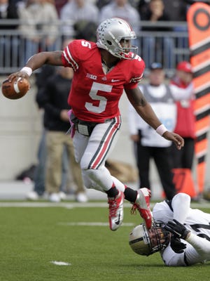 Ohio State quarterback Braxton Miller, left, escapes the grasp of Purdue defensive end Greg Latta during the second quarter of an NCAA college football game Saturday, Oct. 20, 2012, in Columbus, Ohio.