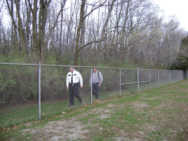Winnebago County Deputy Chief Scott Meyers and another man search along a fence line at Schoonmaker Park in Machesney Park for Katrina Smith. The woman has been missing since Monday.