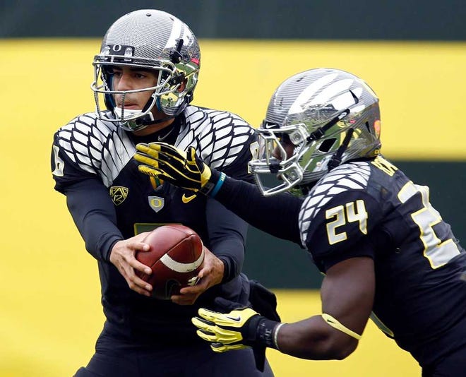 Oregon quarterback Sean Mannion, left, hands off to running back Kenjon Barner during the first half of an NCAA college football game against Colorado in Eugene, Ore., Saturday, Oct. 27, 2012. Mariota passed for 136 yards and two TDs while Barner rushed for 104 yards and two touchdowns as Oregon defeated Colorado 70-14. (AP Photo/Don Ryan)