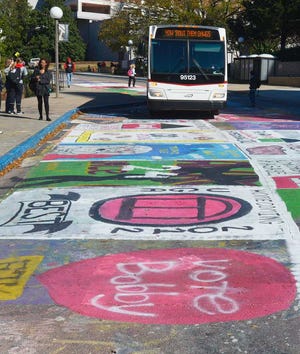A UGA bus pulls onto the newly painted area of Sanford Drive near Sanford Stadium during the Tate Plaza Extravaganza to kick off UGA Homecoming Week on Monday, Oct. 29, 2012 in Athens, Ga. Students painted the Richard Hamm/Staff