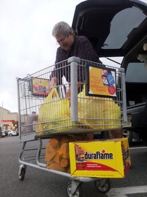 Lawrence Hatez of Eastampton loads his car trunk with essentials on Sunday after a storm preparation shopping trip at ShopRite in Hainesport.