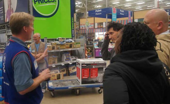 Photo by Bruce A. Scruton — A Lowes manager gives some customers a quick briefing on using a portable electric generator on Monday, Oct. 29, 2012, as another store employee waits to accompany one of them to the check-out.