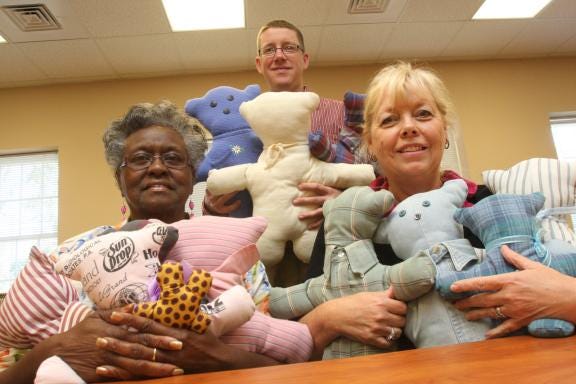 Sharon Martin, Bailey Smith and Lynn Thomas, left to right, hold memory bears that Hospice gives to grieving children after a loved one has passed away. (Ben Earp/The Star)