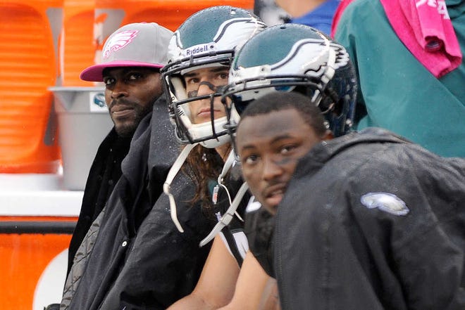 Philadelphia Eagles quarterback Michael Vick, left, sits on the bench with teammates during the second half of an NFL football game against the Atlanta Falcons, Sunday, Oct. 28, 2012, in Philadelphia. The Falcons won 30-17. (AP Photo/Michael Perez)