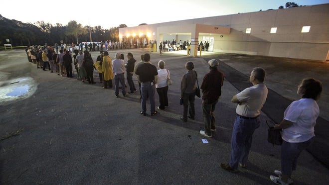 102712 (Damon Higgins/The Palm Beach Post) WEST PALM BEACH - Scores of voters line up just after 7 a.m. Saturday morning outside the Palm Beach County Supervisor of Elections headquarters to vote early.