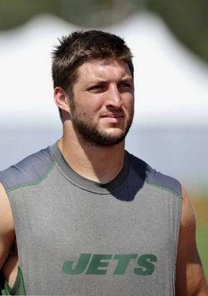 New York Jets quarterback Tim Tebow leaves the field after practice at their NFL football training camp Monday, July 30, 2012, in Cortland, N.Y. (AP Photo/Bill Kostroun)