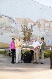 Mebane Mayor Glendel Stephenson, Rett Davis of the New Leaf Society, Sandi Bagby with the city of Mebane and Joy Albright of Destination Downtown are shown in Mebane near one of the group's plantings.