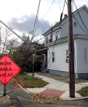 A fallen tree rests on the porch of 440 Poplar Street in Delanco, while a split utility pole remains unsecured. Township officials said the safety risk posed by the pole has displaced occupants of three apartments in the building. It is unknown whether the fallen tree caused the pole’s damage.