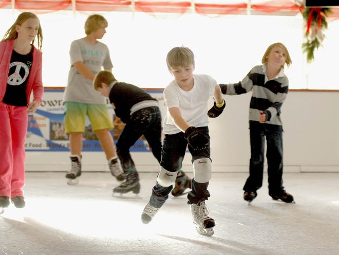 Max Whitney, 8, middle, skates recently with other children at Baytowne on Ice in the Village of Baytowne Wharf at Sandestin.