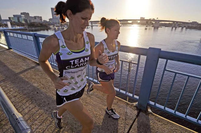 Will.Dickey@Jacksonville.com Dana Stallings (left) and her daughter Haley run on the Main Street Bridge during training on Oct. 15.