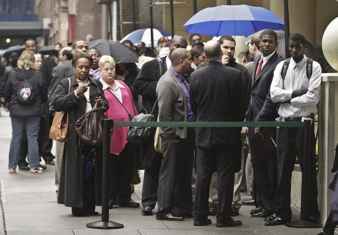 In this Wednesday, Oct. 24, 2012 photo, job seekers wait in line to see employers at the National Career Fairs' job fair in New York.