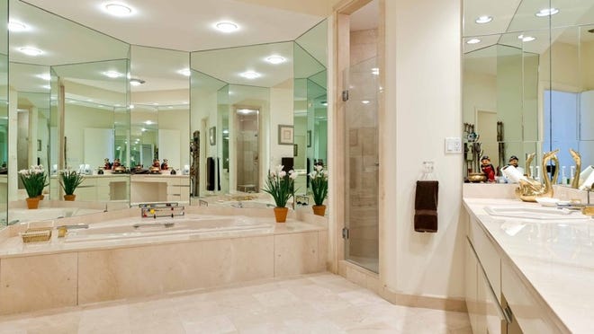The master bath has a honed-marble floor and an abundance of mirrors.