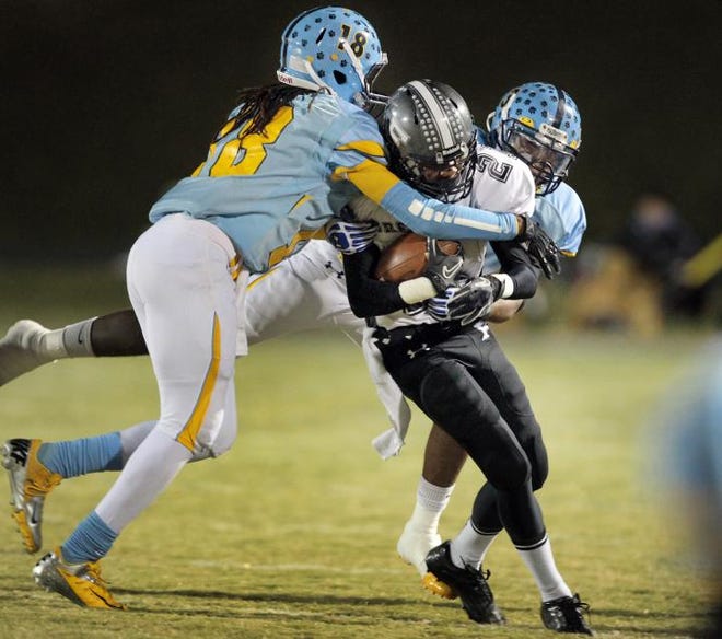 Burns' Travon Hunt (18) and Quintel Houser (3) tackle Forestview's Mo Neal on Friday.