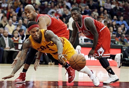 Cleveland Cavaliers' Daniel Gibson (1) tries to grab a loose ball against Chicago Bulls' Taj Gibson and Nate Robinson, right, during the fourth quarter of an NBA basketball game Friday, Nov. 2, 2012, in Cleveland. The Bulls won 115-86. (AP Photo/Mark Duncan)