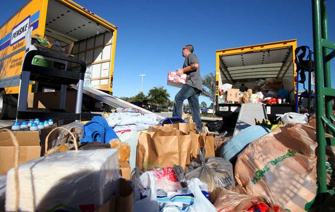 Len Conticello transfers donations from a 16-foot truck, right, to a 26-foot truck, left, on Friday afternoon, Nov. 2, 2012. By DARON DEAN, daron.dean@staugustine.com