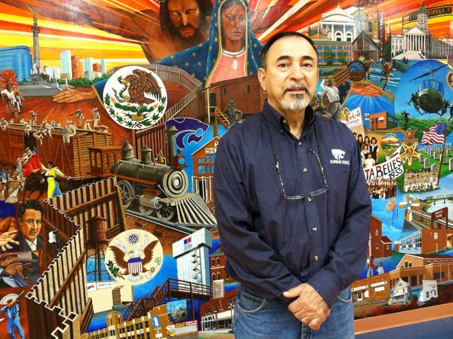 Topeka native Andy Valdivia stands in front of the large, colorful mural he painted in the basement of the Marlo Cuevas-Balandran Activity Center, 216 N.E. Banner. The mural, titled "Our History," depicts the Mexican-Hispanic heritage of Our Lady of Guadalupe Church and the Oakland community.