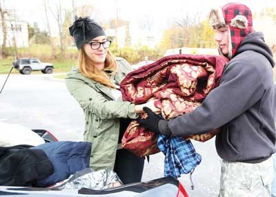Photo by Tracy Klimek/New Jersey Herald Franklin resident Rimma Rivera, left, hands a large comforter to seventeen year old Rocco Menna, of Hardyston, during the donation drive for victims of Hurricane Sandy in the parking lot of Chase Bank in Franklin.