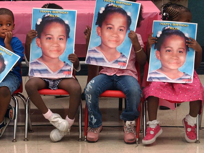 FILE - In this Thursday, Sept. 29, 2005, file photo, children hold posters of missing child, Rilya Wilson, at the Caleb Center in Miami, during a birthday party thrown by community leaders from Rilya's old neighborhood to remember what would have been her ninth birthday. More than a decade after foster child Rilya WilsonÕs disappearance caused a state government shakeup, trial is finally scheduled to begin for the caregiver accused of killing the little girl. Jury selection is scheduled to begin Monday, Nov. 5, 2012, for the trial of Geralyn Graham, who has pleaded not guilty to a first-degree murder charge and has insisted she is innocent.(AP Photo/Miami Herald, Marice Cohn Band)