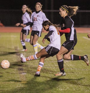 Oliver Ames' High's Clarissa Romero, front, scores the winning goal with 8:41 left in regulation play to beat Brockton High in their Div. 1 South Sectional quarterfinal on Sunday. Looking on is Cardinal Spellman's Siobhan O'Connell (21).