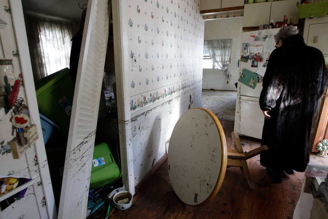 Ginny Flanagan, 70, surveys her damaged kitchen where the muddy marks on the walls show the height reached by floodwaters, in Breezy Point, a neighborhood that was submerged by Sandy's storm surge and remains without power nearly a week after the storm on Sunday.