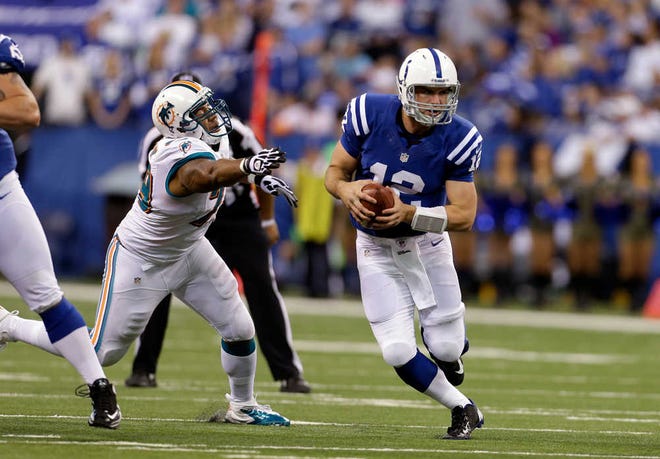 Indianapolis Colts quarterback Andrew Luck eludes Miami Dolphins defensive end Derrick Shelby during the second half of an NFL football game in Indianapolis, Sunday, Nov. 4.