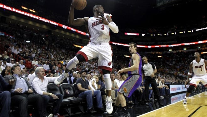 Phoenix Suns' Goran Draic (1) chases Miami Heat's Dwyane Wade (3) as Wade keeps the ball in bounds during the first half of an NBA basketball game in Miami, Monday, Nov. 5, 2012. (AP Photo/J Pat Carter)