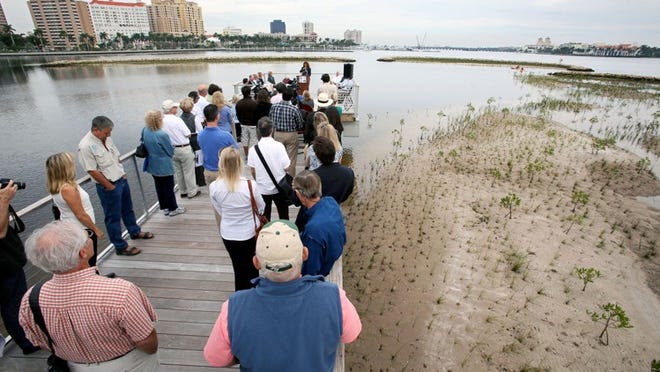 People gather on the boardwalk at the South Cove Natural Area Monday morning for ceremonies opening the restoration project.