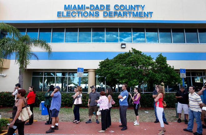 Voters line up to pick up absentee ballots at the Miami-Dade County Elections Department, Tuesday in Doral. Florida voters queued up before dawn Tuesday to cast their ballots as long lines began forming at some precincts across the state.