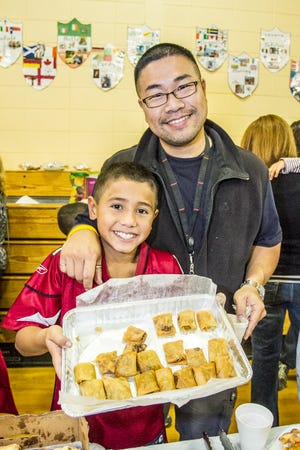 Rhys Chin stands with his Father showing off their interesting mix of Portuguese/Chinese Spring Rolls.