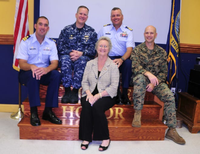 Shelia McNeill, front, with, from left, Lt. Cmdr. Matt Baer, Capt. Harvey L. Guffey, Jr., Cmdr. Steve Love and Lt. Col. Kevin Moody.