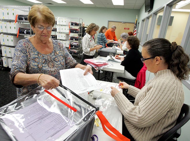 Carol Wilfong, left, and Kim Baxley work with others to count provisional ballots at the Supervisor of Elections Office in Panama City on Wednesday.