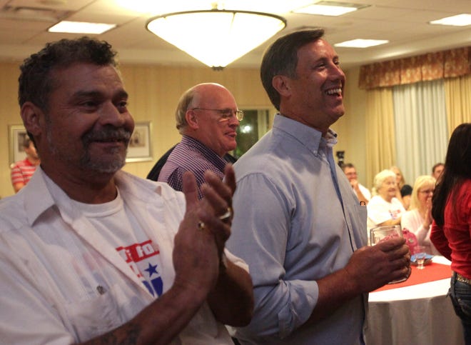 Bay County Commissioner Bill Dozier, right, watches early results in his favor as they are shown on a television during an election watching party at the Hilton Garden Inn in Panama City.
