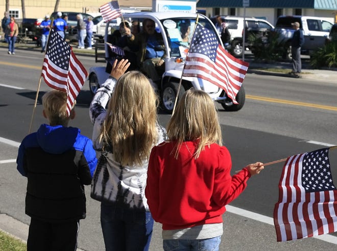 Children wave to a passing vehicle during the 2011 Veterans Day Parade in Panama City.