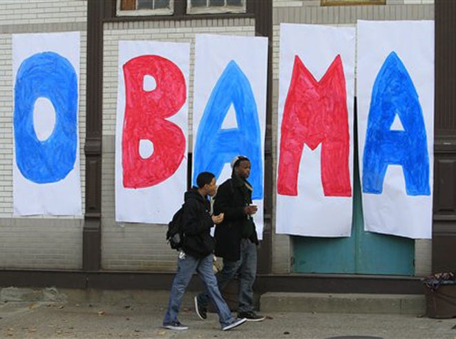 Jaylen Williams, left, and Sean Tyus walk past a homemade Obama sign on their way to school, Wednesday, Nov. 7, 2012, in the Over-the-Rhine neighborhood of downtown Cincinnati. President Barack Obama captured a second White House term on Tuesday over the challenge by Republican Mitt Romney. (AP Photo/Al Behrman)