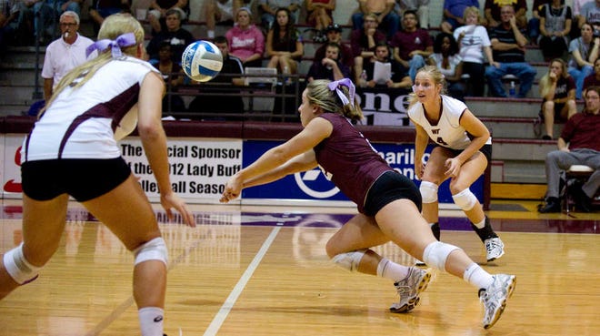 West Texas A&M libero Lauren Beville, center, dives to make a dig against Midwestern State this season. Beville broke the WT career record for digs with 2,251.