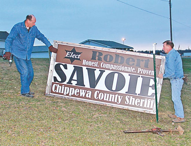 Rudyard resident Gary Shumbarger (left) assists Chippewa County Sheriff Robert Savoie with the removal of a campaign sign on Wednesday in the wake of Tuesday’s election. With literally thousands of signs scattered across the Eastern Upper Peninsula promoting various candidates and causes, there will be plenty of other engaging in this activity in the days and perhaps even weeks to come.